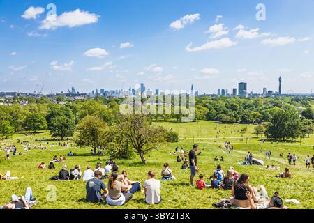 Menschenmassen entspannen sich auf Primrose Hill mit Blick auf die Skyline vom Regents Park. London, UK, 2. Juni 2024 Stockfoto