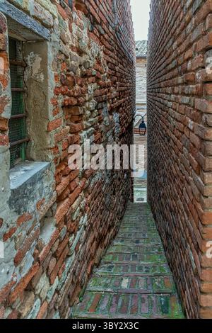 Zwischen zwei schmalen Terrakotta-Mauern liegt die schmalste Gasse Italiens. Ripatransone, Ascoli Piceno, Region Marken, Italien, Europa. Stockfoto