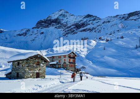 Zwei Personen laufen in Richtung Rifugio Cristina, Alpe Prabello, Bernina Range, Lombardei, Italien Stockfoto