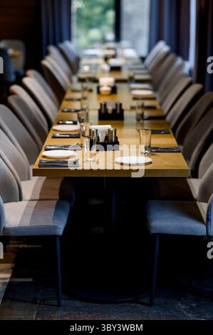 Tischeinstellung. Nahaufnahme von leeren Gläsern, Tellern und Löffeln in einem Restaurant. Schöne Tischdecken warten auf Gäste Stockfoto