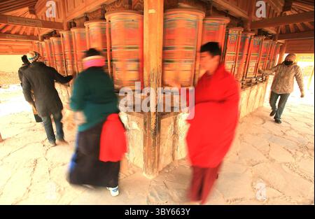 2. Februar 2012, XIAHE, PROVINZ GANSU, CHINA: Tibetische Nomaden, Pilger und Mönche wenden bunte Gebetsmühle rund um das Kloster Labrang, das größte tibetische Kloster außerhalb von Lhasa, vor dem Tibetischen Monlam Festival in Xiahe, Provinz Gansu auf dem tibetischen Plateau, 2. Februar 2012. Zehntausende Tibeter feiern das tibetische Neujahr, indem sie sich auf den Weg in diese Stadt und ihr Kloster Labrang machen, dessen Trennung von der Autonomen Region Tibetisch ein Maß an Schutz vor Han-chinesischen Versuchen bietet, ihre Kultur zu regulieren. (Kreditbild: © Stephen Shaver/ZUM Stockfoto