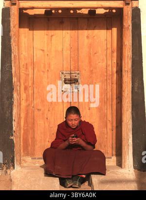 2. Februar 2012, XIAHE, PROVINZ GANSU, CHINA: Ein junger tibetischer Mönch spielt mit seinem Handy im Kloster Labrang, dem größten tibetischen Kloster außerhalb von Lhasa, vor dem Tibetan Monlam Festival in Xiahe, Provinz Gansu auf dem tibetischen Hochplateau, 2. Februar 2012. Zehntausende Tibeter feiern das tibetische Neujahr, indem sie sich auf den Weg in diese Stadt und ihr Kloster Labrang machen, dessen Trennung von der Autonomen Region Tibetisch ein Maß an Schutz vor Han-chinesischen Versuchen bietet, ihre Kultur zu regulieren. (Bild: © Stephen Shaver/ZUMA Press Wire) Stockfoto
