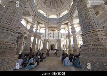 Indische Frau betet zwischen den weißen Marmorsäulen im Adinath-Tempel in Ranakpur, Jain-Tempel, Rajasthan, Indien Stockfoto