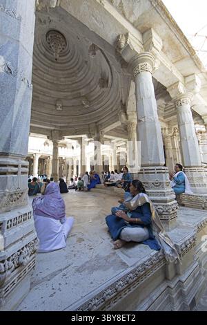 Indische Frau betet zwischen den weißen Marmorsäulen im Adinath-Tempel in Ranakpur, Jain-Tempel, Rajasthan, Indien Stockfoto