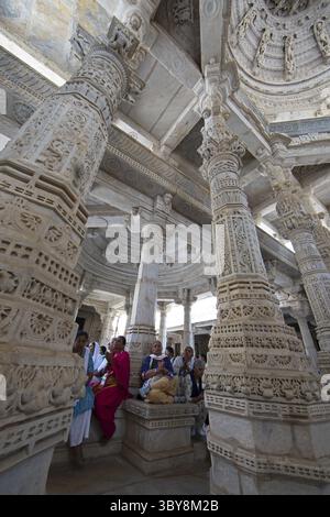 Indische Frau betet zwischen den weißen Marmorsäulen im Adinath-Tempel in Ranakpur, Jain-Tempel, Rajasthan, Indien Stockfoto