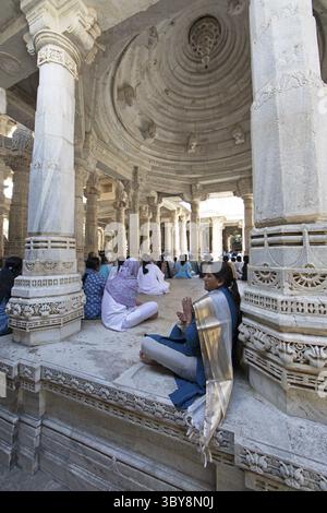 Indische Frau betet zwischen den weißen Marmorsäulen im Adinath-Tempel in Ranakpur, Jain-Tempel, Rajasthan, Indien Stockfoto