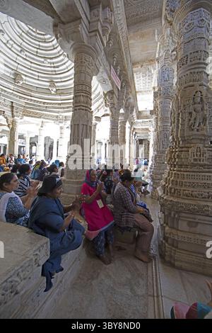 Indische Frau betet zwischen den weißen Marmorsäulen im Adinath-Tempel in Ranakpur, Jain-Tempel, Rajasthan, Indien Stockfoto