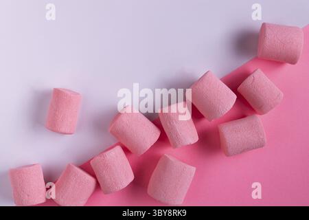 Rosa Marshmallow liegt auf weißem und rosafarbenem Papier, Platz für Text Stockfoto