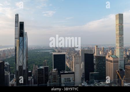 Luftpanorama einer belebten Stadtlandschaft mit modernen Wolkenkratzern und weitläufigem Central Park unter einem bewölkten Himmel, der urbanes Wachstum und architektonische Vielfalt verkörpert. Stockfoto