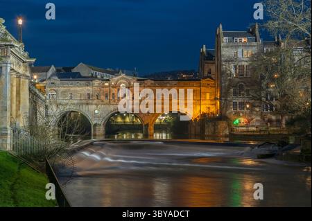 Nächtlicher Blick auf das berühmte georgianische Pulteney Weir und die Brücke auf dem Fluss Avon im Zentrum von Bath, Somerset, England, Großbritannien. Stockfoto