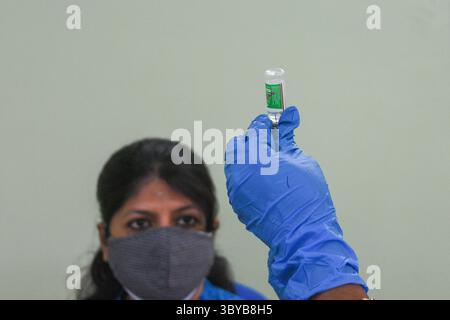 27. April 2021, Kolkata, Westbengalen, Indien: Eine Frau beobachtet, wie ein Arzt eine Dosis COVISHIELD-Impfstoff für die Verabreichung vorbereitet, in einer Gesundheitsklinik in Kalkutta, Indien am 27. April 2021. Die indische Regierung beschleunigt die COVID-19-Impfkampagne angesichts akuter Engpässe bei COVISHIELD und COVAXIN in Indien , wobei die Fälle infolge der zweiten COVID-19-Epidemie in Indien massiv anstiegen (Credit Image: © Debarchan Chatterjee/ZUMA Press Wire). Stockfoto