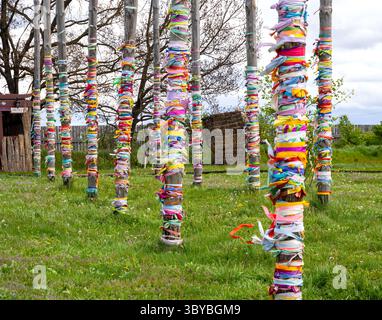 Holzstangen mit mehrfarbigen Bändern, die als Appell an Spirituosen gebunden sind. Gebiet des archäologischen Parks Argamach-Palna. Region Lipetsk Stockfoto