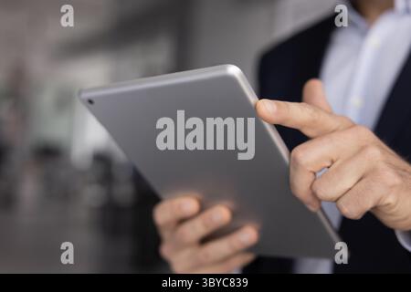 Nahaufnahme eines professionellen Mannes, der ein digitales Tablet verwendet Stockfoto