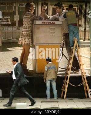 14. Mai 2009, PEKING, CHINA: Zwei chinesische Arbeiter kleben am 14. Mai 2009 eine große Werbung für eine Mode-Boutique im amerikanischen Stil, die noch in China hergestellt wurde. Europäische und amerikanische Modedesigner, die die Kreditkrise in Mitleidenschaft ziehen, können auf die wachsende Zahl der chinesischen Nouveau-reichen Frauen schauen, um den Umsatz zu steigern. Als die chinesische Wirtschaft in den letzten fünf Jahren jährlich um mehr als 10 Prozent Anstieg, rühmte sich das Land bis Ende 2006 mit 345.000 Millionären (Vermögenswerte in US-Dollar), von denen ein Drittel Frauen waren, so ein Bericht Stockfoto