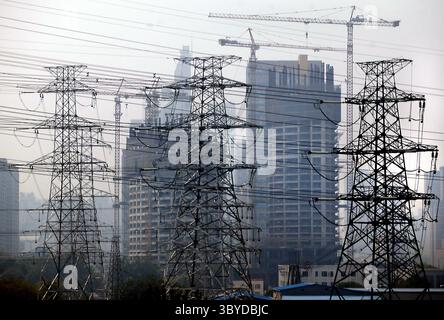 14. Mai 2009, PEKING, CHINA: Riesige elektrische Pylonen fahren an einem neuen Gewerbekomplex vorbei, der am 14. Mai 2009 in Peking gebaut wird. Die chinesische Wirtschaft dürfte sich bis zur zweiten Jahreshälfte erholen und könnte dazu beitragen, Asien und Amerika aus dem Einbruch zu holen, wie die Weltbank kürzlich prognostizierte. (Bild: © Stephen Shaver/ZUMA Press Wire) Stockfoto
