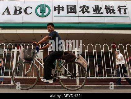 30. Juni 2010, PEKING, CHINA: Ein Chinese fährt am 30. Juni 2010 mit dem Fahrrad an einer Niederlassung der chinesischen Landwirtschaftsbank in Peking vorbei. Die Agricultural Bank of China hat am Mittwoch ein Aktienangebot im Wert von 23,2 Milliarden Dollar eröffnet, da China sich bemüht, depressive Regionen im Herzen des ländlichen Kreditgebers zu entwickeln. (Bild: © Stephen Shaver/ZUMA Press Wire) Stockfoto