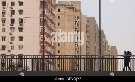 11. März 2011, PEKING, CHINA: Eine Chinesin spaziert am 11. März 2011 an neuen Wohnsiedlungen in der Innenstadt von Peking vorbei. Nachdem die USA 2010 als größter Baumarkt überholt wurden, wird sich Chinas Bausektor bis 2020 auf 2,5 Billionen US-Dollar mehr als verdoppeln. (Bild: © Stephen Shaver/ZUMA Press Wire) Stockfoto