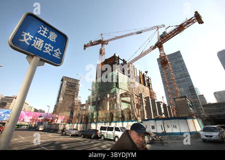11. März 2011, PEKING, CHINA: Ein Chinese läuft am 11. März 2011 an einer Baustelle in der Innenstadt von Peking vorbei. Nachdem die USA 2010 als größter Baumarkt überholt wurden, wird sich Chinas Bausektor bis 2020 auf 2,5 Billionen US-Dollar mehr als verdoppeln. (Bild: © Stephen Shaver/ZUMA Press Wire) Stockfoto
