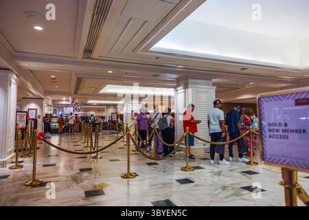 Gäste stehen in der Schlange an der Hotelrezeption in Las Vegas mit goldenen Barrieren und Marmorboden. Las Vegas. USA. Stockfoto