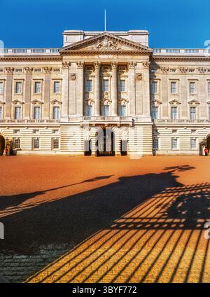 Die große Fassade des Buckingham Palace mit unverwechselbaren Schatten im Innenhof des Vordergrundes Stockfoto