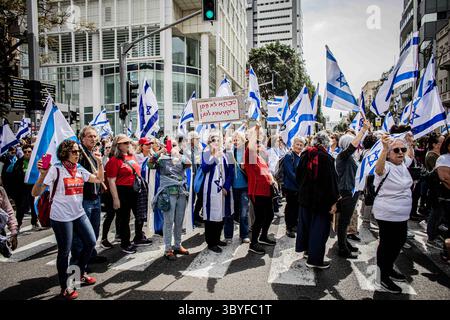 22. März 2023, Tel Aviv, Israel: Eine ältere Frau hält ein Plakat, als sie die Straße überquert, auf der sie sagt, dass Oma während eines Protests gegen die gerichtliche Reform keine Diktatur zulassen wird. In Jerusalem und Tel Aviv fanden Proteste gegen die Justizreform statt, während die Koalition ihre umstrittenen Pläne vorantreibt. (Foto: © Eyal Warshavsky/SOPA Images via ZUMA Press Wire) Stockfoto