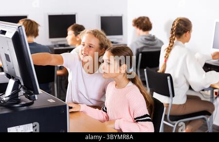 Porträt weiblicher und männlicher Schüler, die im Klassenzimmer am Computer arbeiten Stockfoto