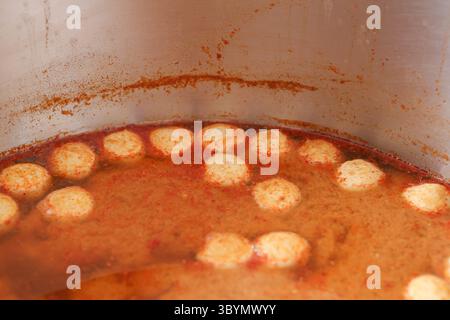 Fleischbällchen schwimmen in roter Suppe. Die Fleischbällchen schweben in der Soße von Khanom Jeen. Stockfoto