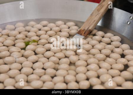 Fleischbällchen werden in heißem Wasser in einer Pfanne gekocht. Fleischbällchen werden in heißem Wasser in einer Pfanne gekocht. Stockfoto