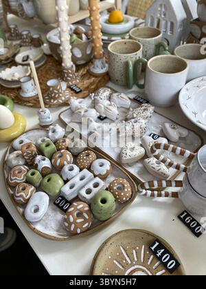 Handgefertigte Keramikschmuck auf dem Tisch mit Preisschildern, ideal für festliche Hintergründe. Mobiles Foto Stockfoto