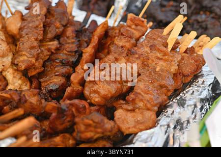 Gegrilltes Schweinefleisch-Barbecue beim Thai Street Food Festival. Traditionelle thailändische Spieße werden auf dem Markt im Freien serviert Stockfoto