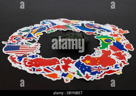 Kleines Spielzeug Militärpanzer in einem Zentrum verschiedener Länder Karten auf schwarzem Hintergrund Stockfoto