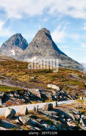 Norwegische Scenic Route 63 , Norwegen,. Die majestätischen Berge erheben sich über einer malerischen Straße, umgeben von felsigem Gelände und üppigem Grün, und schaffen ein einladendes A Stockfoto
