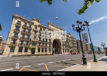 Santander, Spanien. Das zweiflügelige Banco de Santander-Gebäude wird von einem monumentalen Bogen über der Straße mit neoklassizistischen Skulpturen und symmetrischen Ziegelsteinen verbunden Stockfoto