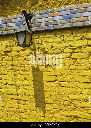 Kolumbien, Cali, alte Laterne auf gelber Ziegelwand Stockfoto