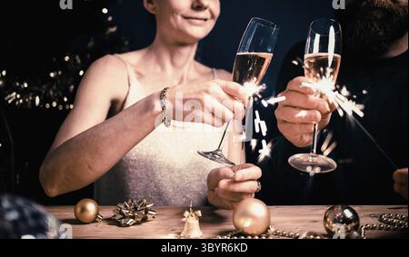 Glückliches Paar mit Glitzern und Sektgläsern Neujahrsparty Stockfoto