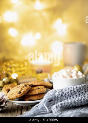 Weihnachtlicher Hintergrund mit Kakao, Marshmallow. Gemütlicher Abend, Tasse Getränk, Weihnachtsdekoration, Kerzen und Lichtergirlanden Stockfoto