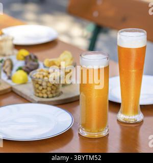 Bierbecher, Gläser mit Snacks auf dem Tisch Stockfoto