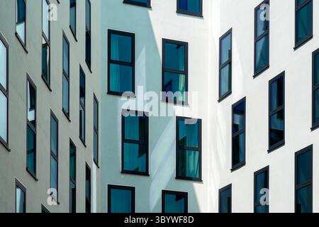 Wohngebäude mit versetzten modernen Fenstern und minimaler Fassade Stockfoto