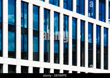 Moderne Bürofassade mit weißem vertikalem Rahmen und blauem Glas Stockfoto