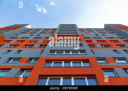 Helles rot-graues Hochhaus mit geometrischem Fensterlayout Stockfoto