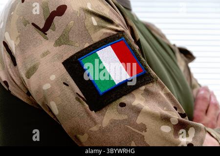 Ein Mann in Uniform mit italienischer Flagge auf dem Ärmel und Armeeabzeichen Stockfoto