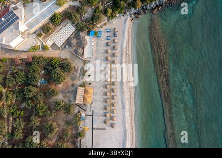 Blick aus der Vogelperspektive auf den Top Down of a Beach in Griechenland in der Nähe von Tyros mit Stühlen und Sonnenschirmen Stockfoto