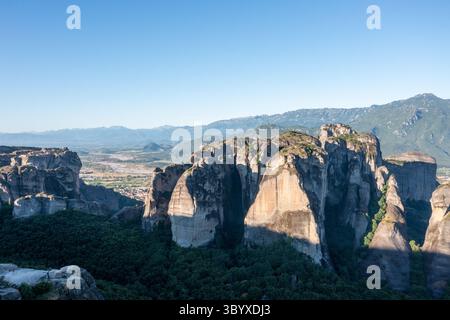 Luftaufnahme einer großen Felsformation in Meteora Griechenland mit Bergen im Hintergrund Stockfoto