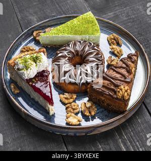 Schöner Donut, Schokoladenkuchen, Tiramisu auf dem blauen Teller, Draufsicht Stockfoto