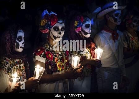 Merida, Cementerio General, Mexiko - 31. Oktober 2018: Die drei Frauen mit Catrina Kunden und Mann mit weissen cowboy Kleid mit skull Make-up Holding kann Stockfoto