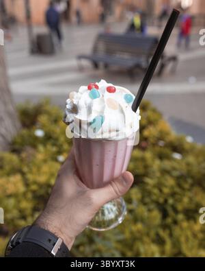 Mann hält großes Eis mit grünem Hintergrund Stockfoto