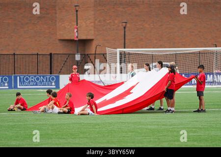 Toronto, Kanada. Juli 2025. Die Kinder erweitern die kanadische Flagge, bevor sie das Spiel der kanadischen Premier League zwischen Vancouver FC und York United im York Lions Stadium starten. Am 19. Juli 2025 in Toronto, Kanada. (Foto: Leonardo Ramirez/Eyepix Group/SIPA USA) Credit: SIPA USA/Alamy Live News Stockfoto