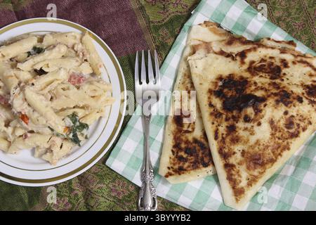 Pasta Carbonara mit italienischem Fladenbrot auf einem rustikalen Küchentisch Stockfoto