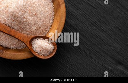 Feines Himalaya-Salz in Schüssel und Löffel - Rosa Kristalle Stockfoto