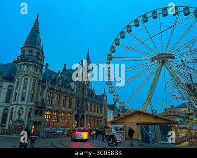 Festliches Riesenrad hinter der Kathedrale von Gent mit weihnachtsmarkt-Glühen Stockfoto